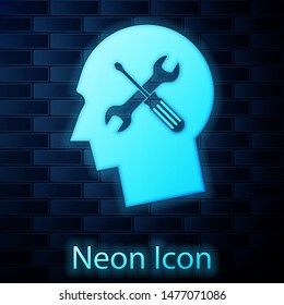 Glowing neon Human head with with screwdriver and wrench icon isolated on brick wall background. Artificial intelligence. Symbol work of brain.  Vector Illustration