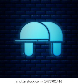 Glowing neon Hunter hat icon isolated on brick wall background. Plaid winter hat.  Vector Illustration