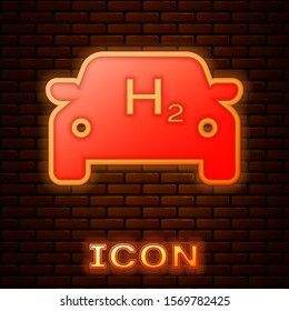 Glowing neon Hydrogen car icon isolated on brick wall background. H2 station sign. Hydrogen fuel cell car eco environment friendly zero emission.  Vector Illustration