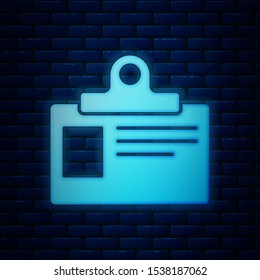 Glowing neon Identification badge icon isolated on brick wall background. It can be used for presentation, identity of the company, advertising.  Vector Illustration