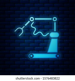 Glowing neon Industrial machine robotic robot arm hand factory icon isolated on brick wall background. Industrial robot manipulator.  Vector Illustration