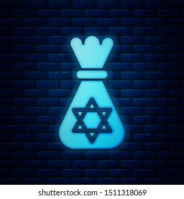 Glowing neon Jewish money bag with star of david icon isolated on brick wall background. Currency symbol.  Vector Illustration