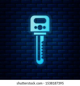 Glowing neon Key icon isolated on brick wall background.  Vector Illustration