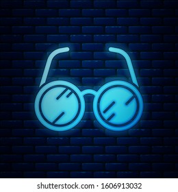 Glowing neon Laboratory glasses icon isolated on brick wall background.  Vector Illustration