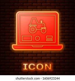 Glowing neon Laptop application for control a autonomous tractor on a smart farm icon isolated on brick wall background. Smart agriculture implement.  Vector Illustration