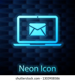 Glowing neon Laptop with envelope and open email on screen icon isolated on brick wall background. Email marketing, internet advertising concepts. Vector Illustration