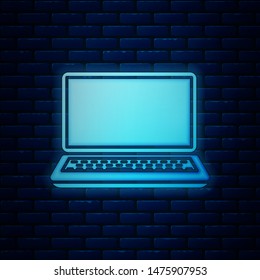 Glowing neon Laptop icon isolated on brick wall background. Computer notebook with empty screen sign.  Vector Illustration