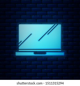 Glowing neon Laptop icon isolated on brick wall background. Computer notebook with empty screen sign.  Vector Illustration