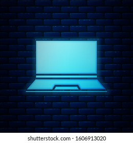 Glowing neon Laptop icon isolated on brick wall background. Computer notebook with empty screen sign.  Vector Illustration