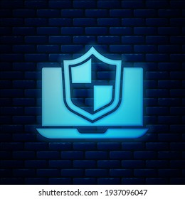 Glowing neon Laptop protected with shield icon isolated on brick wall background. PC security, firewall technology, privacy safety.  Vector