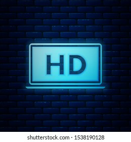 Glowing neon Laptop screen with HD video technology icon isolated on brick wall background.  Vector Illustration