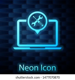Glowing neon Laptop with screwdriver and wrench icon isolated on brick wall background. Adjusting, service, setting, maintenance, repair, fixing.  Vector Illustration