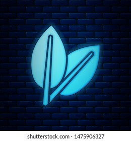 Glowing neon Leafs icon isolated on brick wall background. Fresh natural product symbol.  Vector Illustration