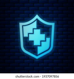 Glowing neon Life insurance with shield icon isolated on brick wall background. Security, safety, protection, protect concept.  Vector
