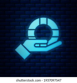 Glowing neon Lifebuoy in hand icon isolated on brick wall background. Lifebelt symbol.  Vector