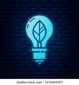 Glowing neon Light bulb with leaf icon isolated on brick wall background. Eco energy concept. Alternative energy concept.  Vector Illustration