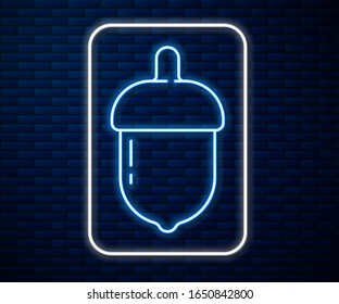 Glowing neon line Acorn icon isolated on brick wall background.  Vector Illustration