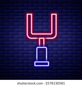 Glowing neon line American football goal post icon isolated on brick wall background. Colorful outline concept. Vector