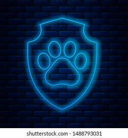 Glowing neon line Animal health insurance icon isolated on brick wall background. Pet protection icon. Dog or cat paw print.  Vector Illustration