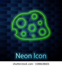 Glowing neon line Asteroid icon isolated on brick wall background.  Vector Illustration