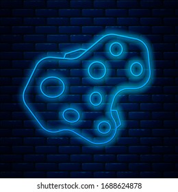 Glowing neon line Asteroid icon isolated on brick wall background.  Vector Illustration