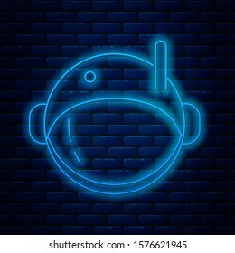 Glowing neon line Astronaut helmet icon isolated on brick wall background.  Vector Illustration
