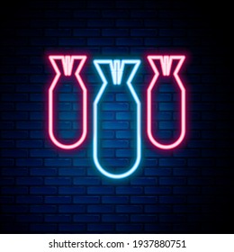 Glowing neon line Aviation bombs icon isolated on brick wall background. Rocket bomb flies down. Colorful outline concept. Vector
