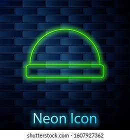 Glowing neon line Beanie hat icon isolated on brick wall background.  Vector Illustration