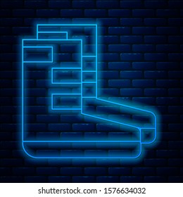 Glowing neon line Boots icon isolated on brick wall background. Diving underwater equipment.  Vector Illustration