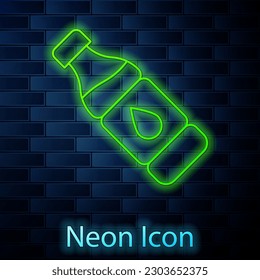 Glowing neon line Bottle of water icon isolated on brick wall background. Soda aqua drink sign.  Vector