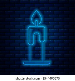 Glowing neon line Burning candle icon isolated on brick wall background. Cylindrical aromatic candle stick with burning flame. Happy Halloween party.  Vector Illustration