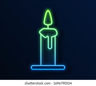 Glowing neon line Burning candle in candlestick icon isolated on blue background. Cylindrical candle stick with burning flame.  Vector Illustration