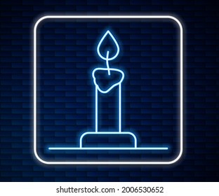 Línea de neón brillante Burning vela en icono de candelabro aislado en el fondo de la pared de ladrillo. Palo cilíndrico de velas con llama ardiente.  Vector