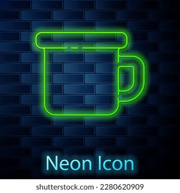 Glowing neon line Camping metal mug icon isolated on brick wall background.  Vector Illustration