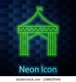 Glowing neon line Camping tent icon isolated on brick wall background. Carnival camping tent. Amusement park.  Vector Illustration
