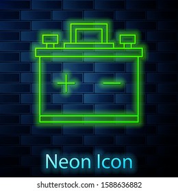 Glowing neon line Car battery icon isolated on brick wall background. Accumulator battery energy power and electricity accumulator battery.  Vector Illustration