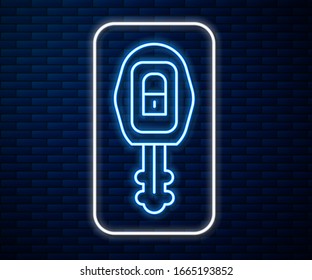 Glowing neon line Car key with remote icon isolated on brick wall background. Car key and alarm system.  Vector Illustration