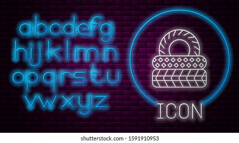 Glowing neon line Car tire icon isolated on brick wall background. Neon light alphabet. Vector Illustration