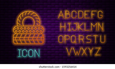 Glowing neon line Car tire icon isolated on brick wall background. Neon light alphabet. Vector Illustration