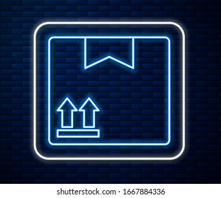 Glowing neon line Cardboard box with traffic symbol icon isolated on brick wall background. Box, package, parcel. Delivery, transportation and shipping.  Vector Illustration
