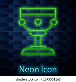 Glowing neon line Christian chalice icon isolated on brick wall background. Christianity icon. Happy Easter. Vector Illustration