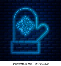 Glowing neon line Christmas mitten icon isolated on brick wall background.  Vector Illustration