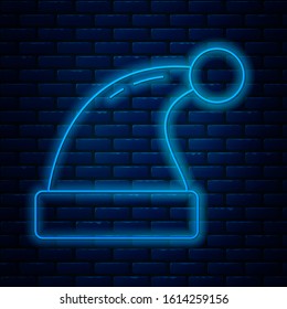 Glowing neon line Christmas Santa Claus hat icon isolated on brick wall background. Merry Christmas and Happy New Year.  Vector Illustration