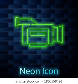 Línea de neón brillante Icono de cámara de cine aislado en el fondo de pared de ladrillo. Cámara de video. Signo de película. Proyector de película. Vector