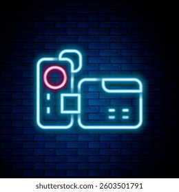 Glowing neon line Cinema camera icon isolated on brick wall background. Video camera. Movie sign. Film projector. Colorful outline concept. Vector