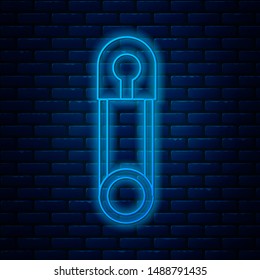 Glowing neon line Classic closed steel safety pin icon isolated on brick wall background.  Vector Illustration