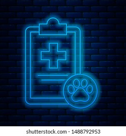 Glowing neon line Clipboard with medical clinical record pet icon isolated on brick wall background. Health insurance form. Medical check marks report.  Vector Illustration