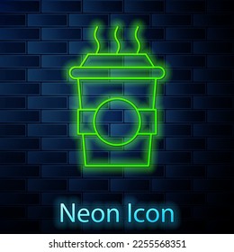 Glowing neon line Coffee cup to go icon isolated on brick wall background.  Vector