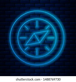 Glowing neon line Compass icon isolated on brick wall background. Windrose navigation symbol. Wind rose sign.  Vector Illustration