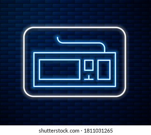 Glowing neon line Computer keyboard icon isolated on brick wall background. PC component sign.  Vector Illustration